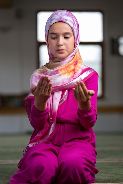 Religiöses muslimisches Mädchen, das in der Moschee betet.