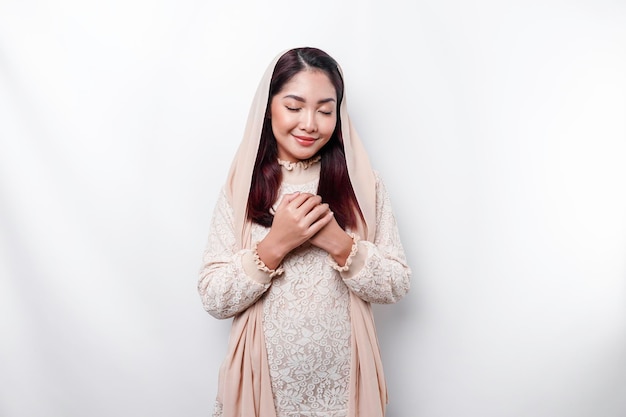 Religiosa hermosa chica musulmana asiática con un pañuelo en la cabeza rezando a Dios