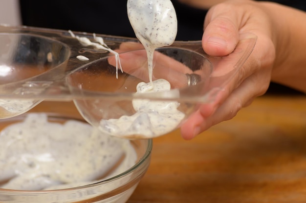 Relleno de moldes con chocolate blanco derretido y trocitos de galleta para preparar huevos de Pascua