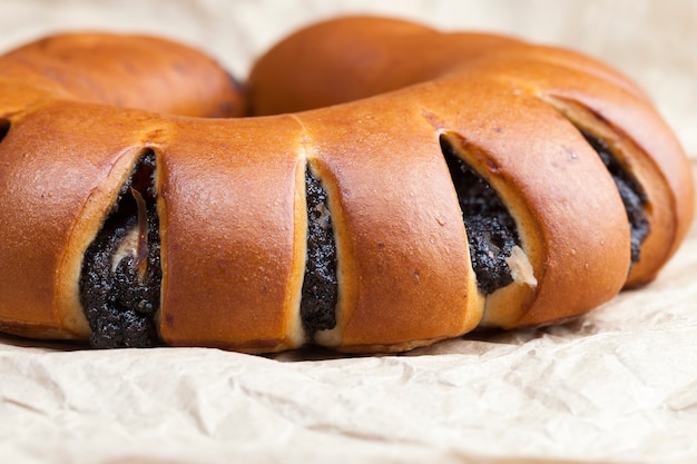 Foto el relleno de semillas de amapola y huevos en un bollo de postre con bollo fresco con un relleno negro de semillas de amapola.