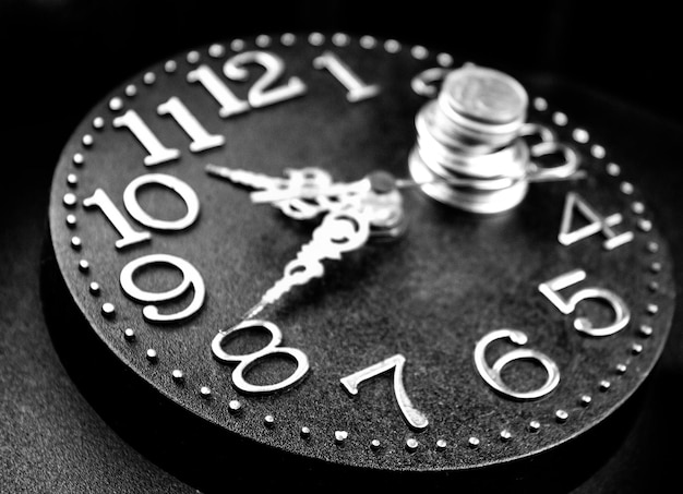 Relógio antigo e moedasDinheiro no mostrador do relógioConceito de tempo e dinheiro O custo do tempo