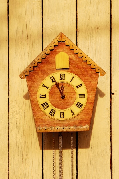 Foto relógio antigo em uma parede de madeira clara. relógio vintage. relógio de cuco