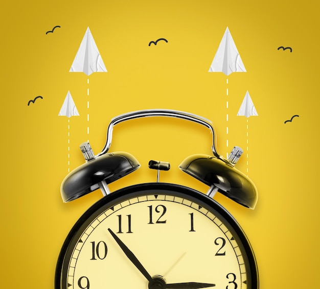 Relógio com aviões de papel em fundo amarelo o tempo voa conceito