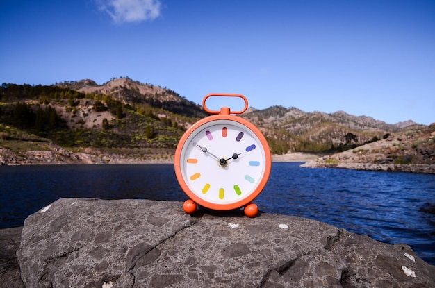 Relógio de bolso vintage clássico do conceito de tempo nas rochas vulcânicas