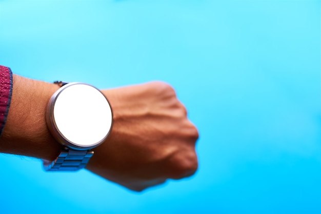 Foto relógio inteligente na mão no fundo azul
