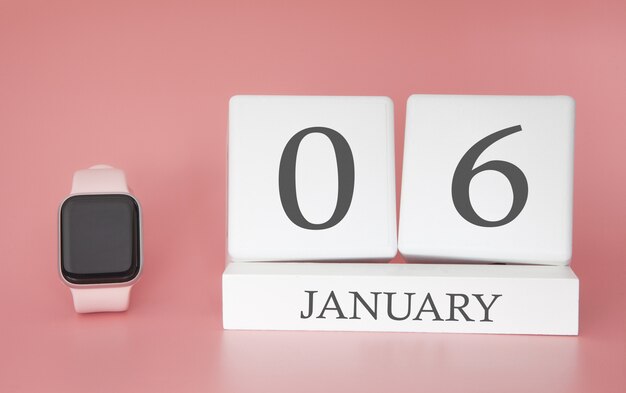 Relógio moderno com calendário de cubo e data 6 de janeiro em fundo rosa. conceito de férias de inverno.