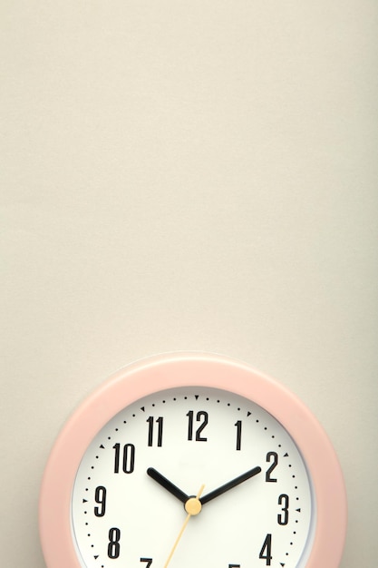 Relógio rosa em fundo cinza Vista superior Foto vertical