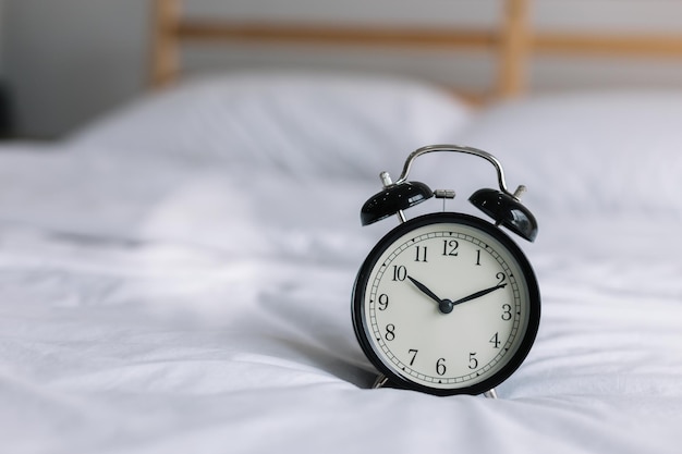 Reloj de alarma en la cama en casa