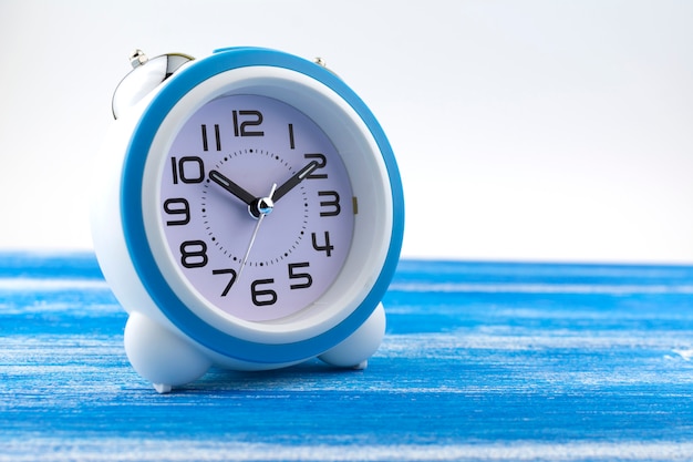 Foto el reloj de alarma está en un tablero azul pintado.