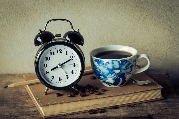 Foto reloj de alarma vintage con café