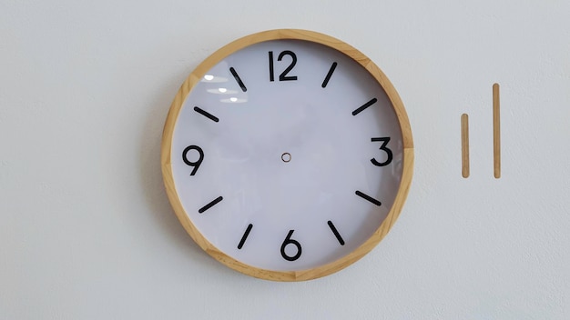 Reloj analógico en pared de hormigón blanco con minutero y horario para crear tiempos