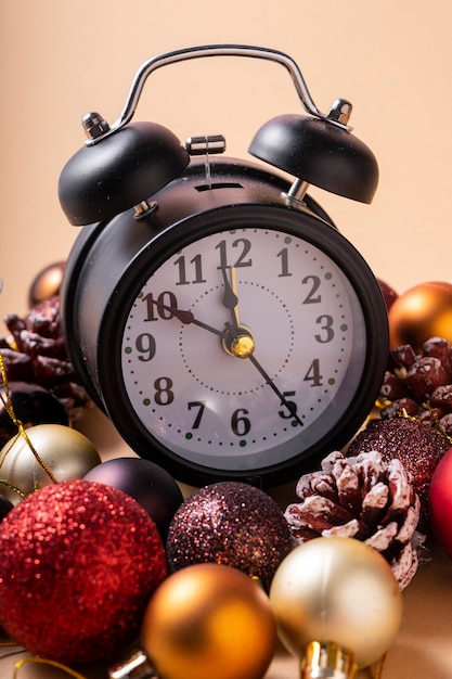 Reloj de año nuevo con manecillas de diez a doce con bolas de plástico navideñas y juguetes navideños.