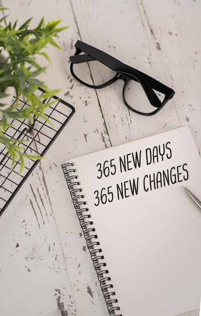 Reloj de arena y bloc de notas con inscripción motivacional 365 nuevos días 365 oportunidades