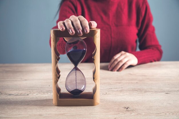 Foto reloj de arena de mano de mujer