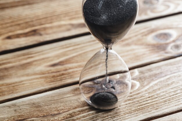 Foto reloj de arena moderno en mesa de madera