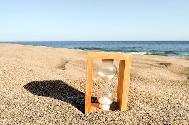 Reloj de arena en la playa de arena