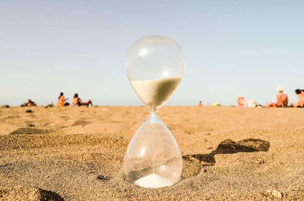 Reloj de arena en la playa de arena