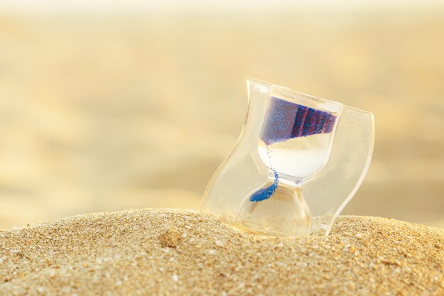 Foto reloj de arena en la playa de arena