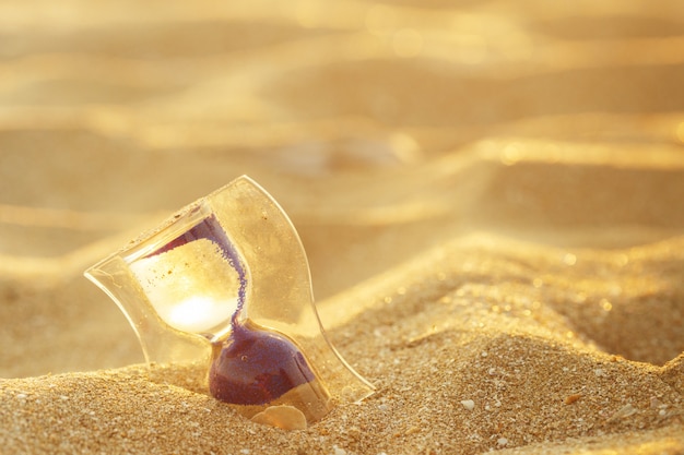 Reloj de arena en la playa de arena