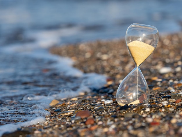 Reloj de arena en la playa a la orilla del mar