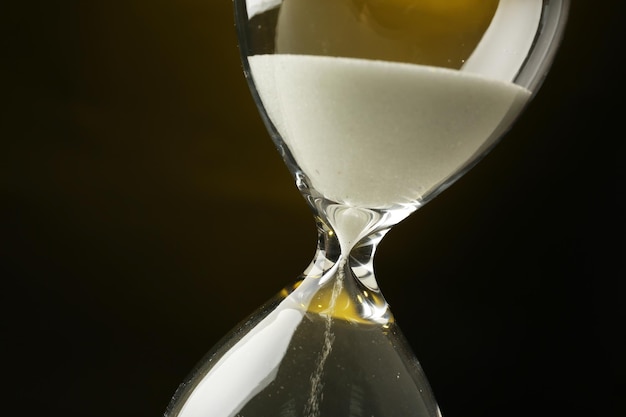 Reloj de arena sobre un fondo amarillo oscuro