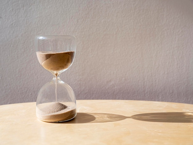 Foto reloj de arena sobre mesa de madera