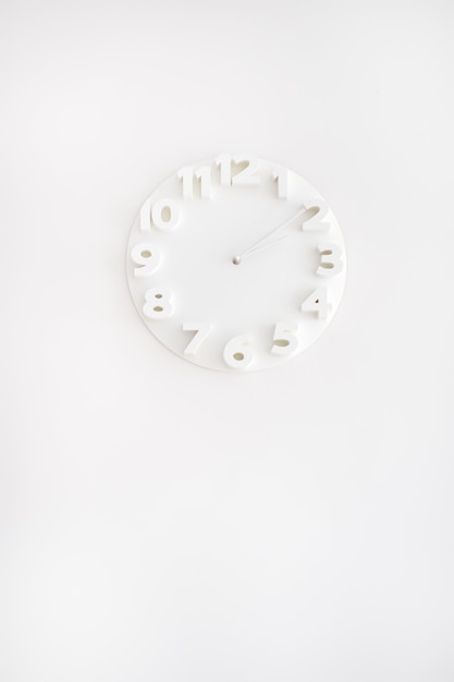 Foto reloj blanco en pared blanca