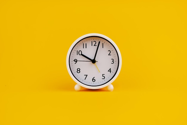 Reloj blanco sobre fondo amarillo concepto de tiempo Planificación del tiempo