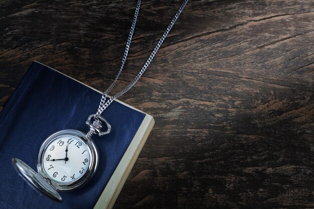 Foto reloj de bolsillo en un libro viejo, un cuaderno.