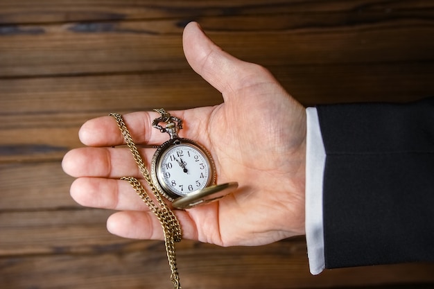 Un reloj de bolsillo en manos de un hombre.