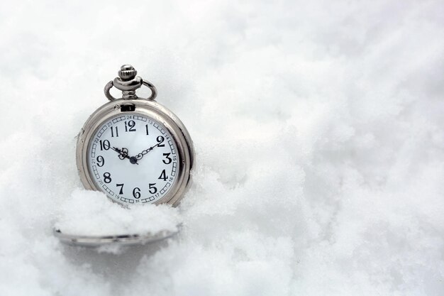 Reloj de bolsillo sobre fondo blanco de nieve