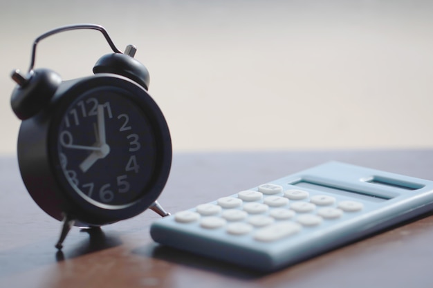 Reloj y calculadora en el fondo de madera para las finanzas