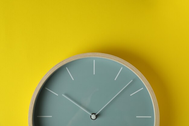 Reloj de casa de madera estándar sobre fondo amarillo