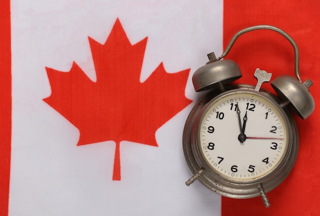 Reloj despertador vintage en el fondo de la bandera de Canadá