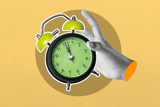 Reloj de despertador vintage en la mano sobre un fondo amarillo