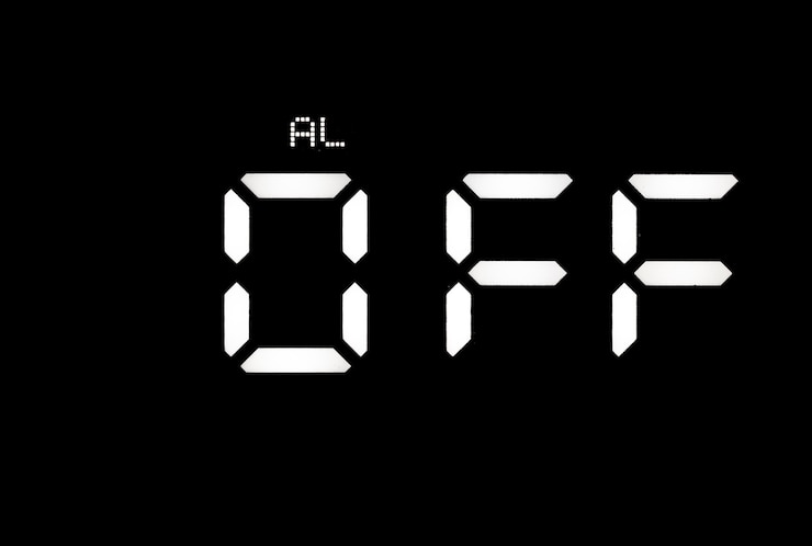 Foto reloj digital led blanco real sobre un fondo negro que muestra la alarma apagada.