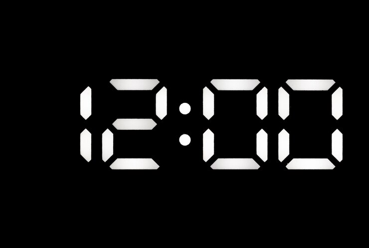 Foto reloj digital led blanco real sobre un fondo negro que muestra la hora 1200