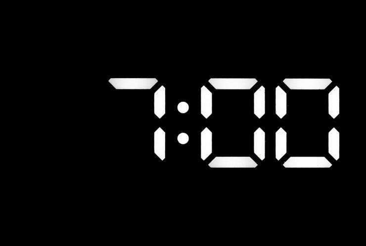 Foto reloj digital led blanco real sobre un fondo negro que muestra el tiempo 700
