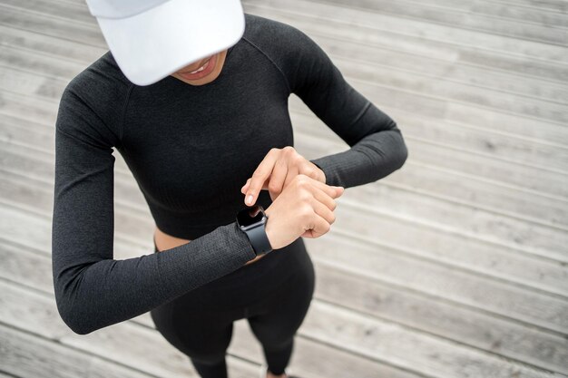 Reloj de fitness a mano Una entrenadora hace entrenamiento de fitness activo con ejercicios de fuerza