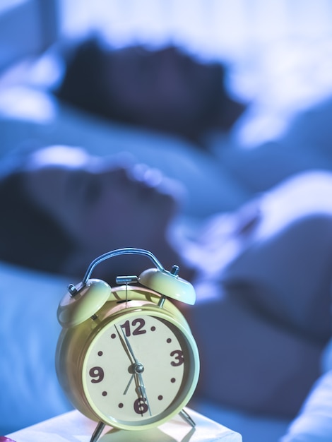 Foto el reloj en el fondo de la pareja dormida. noche