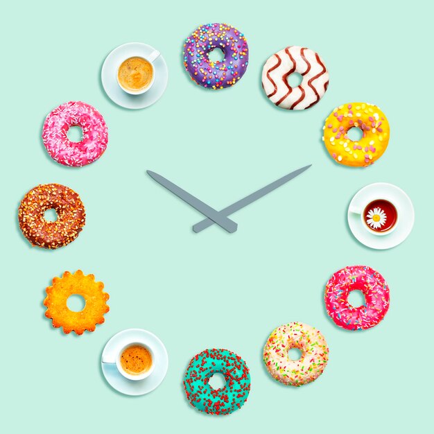 Foto reloj hecho de coloridas tazas de donuts y galletas.