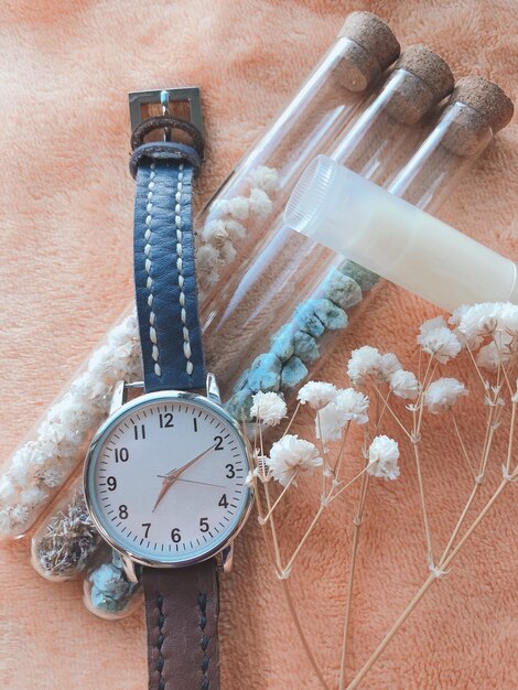 Foto reloj hecho a sí mismo lápiz labial y flores hechas a sí mismo