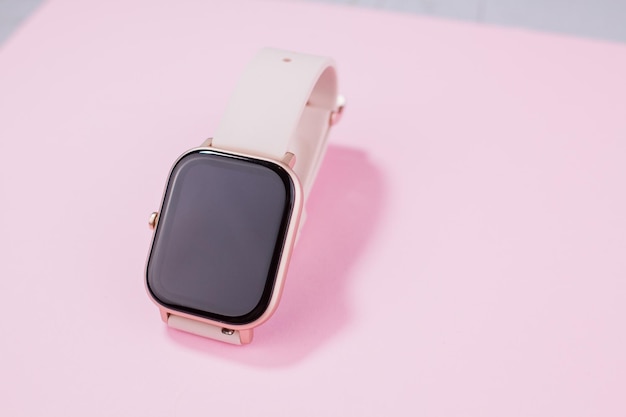 Un reloj inteligente para mujer con fondo rosa