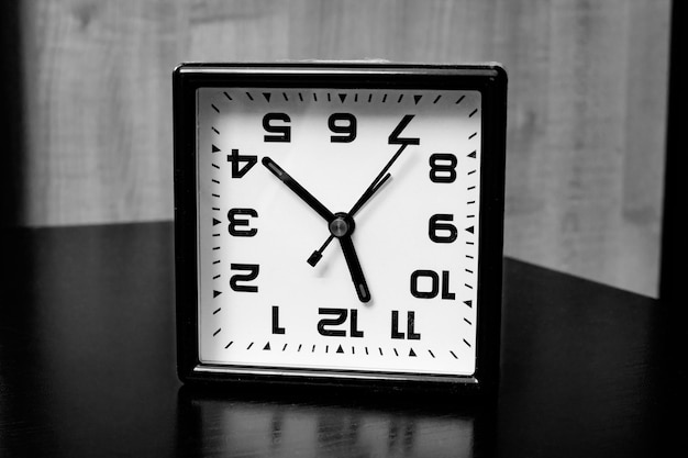 Foto reloj invertido con flechas en blanco y negro