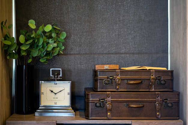 Reloj y maleta vieja de cuero en el dormitorio. Dormitorio de diseño moderno. Diseño de interiores.
