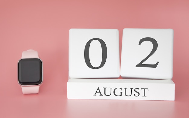 Reloj moderno con calendario de cubo y fecha 02 de agosto en la pared rosa. Concepto de vacaciones de verano.