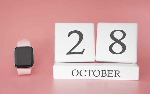 Reloj moderno con calendario de cubo y fecha 28 de octubre sobre fondo rosa