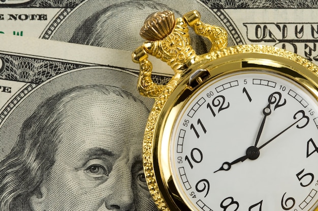 Reloj de oro en billetes de dinero en dólares