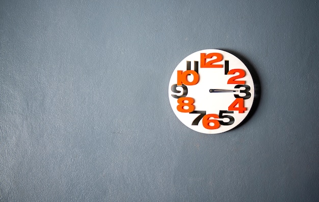 Foto el reloj de pared blanco colgado en la pared gris, apropiado el fondo, espacio de copia de idea