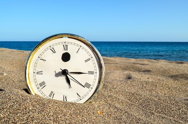 Reloj en la playa de arena